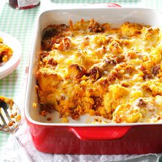 a casserole dish with meat and cheese in it on a green tablecloth