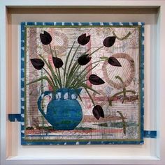 a blue vase filled with lots of flowers on top of a white tablecloth covered wall