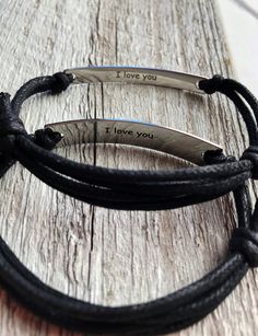 two black leather bracelets with i love you written on them