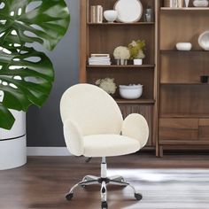 a white office chair sitting in front of a book shelf