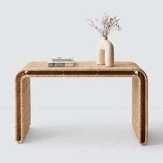 a table with a vase and some books on it next to a book shelf that is made out of wicker