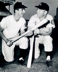 two baseball players are posing with their bats