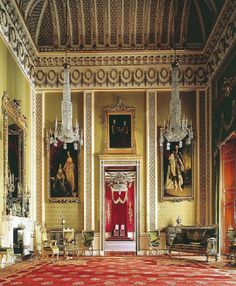 the green drawing room is decorated with gold and red curtains, chandeliers, and paintings