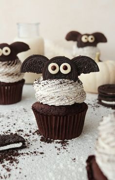 cupcakes decorated with chocolate frosting and googly eyes are sitting on a table