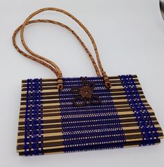 Thailand Purse Handbag Woven Straw Rattan Purple Handmade Flower Brown Womens This is a nice preowned purse handbag from Thailand.  This was a gift and was never used.  It is hand crafted with rattan and thread and grass.  It has a decorative flower on the front that hooks around and closes on the back.  It has a double handle that is woven.  Inside it is lined with black fabric and has one pocket and has a tag which says, "Made in Thailand". The purse without the strap measures approximately 5. Flower Brown, Unique Purses, Handmade Flower, Handmade Flowers, Black Fabric, Beautiful Things, Flower Decorations, Purses And Handbags, Straw Bag