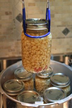 mason jar filled with beans sitting on top of a metal pan next to canisters