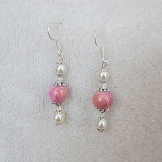 Drop earrings in nice feminine colour combination will nicelý compliment many outfits. The earrings have a comfortable length of 5 centimetres so they can be worn any and every day. There are two beads in pearl white colours, see through spacer beads and a beautiful pink bead with golden hue on each Pink Beaded Earrings, Pearl Earrings Designs, Pink Drop Earrings, Feminine Earrings, Feminine Jewelry, Delicate Feminine, Gift Sister, Beaded Jewlery, Bead Charms Diy