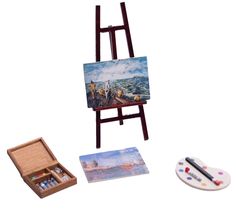 a miniature easel with paint and watercolors on it next to a painting