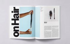 an open magazine with a hand holding a hair brush