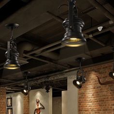 an empty room with exposed brick walls and industrial lights hanging from the ceiling above it