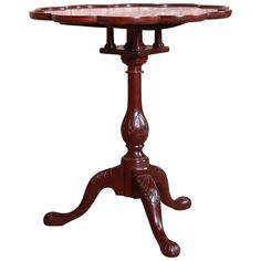 a wooden table with an ornate design on the top and bottom, sitting against a white background