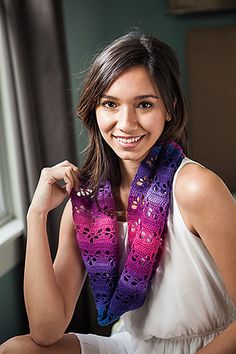 a woman wearing a purple and blue scarf posing for a photo in front of a window