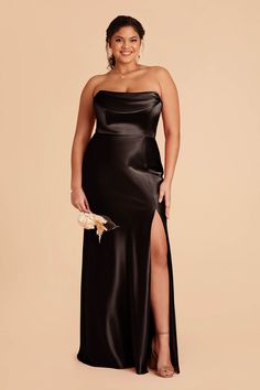 a woman wearing a black dress with a slit