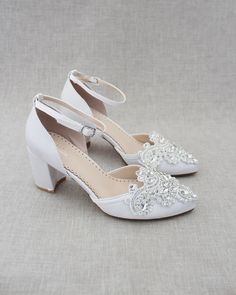 a pair of white wedding shoes sitting on top of a table