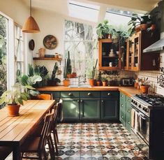 a kitchen filled with lots of green cabinets and counter top next to a wooden table