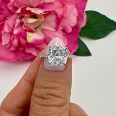 a close up of a person's hand with a diamond ring