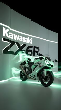 a white motorcycle parked in front of a wall with kawasaki logo on it's side