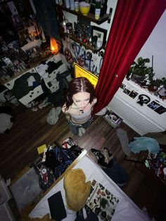 a woman is sitting on the floor in her messy room