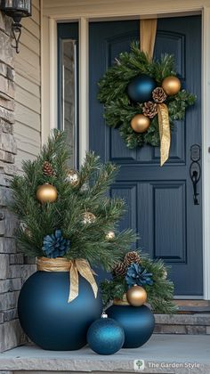 two blue vases with christmas decorations on the front porch