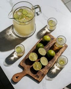 limes and limeade on a cutting board with glasses