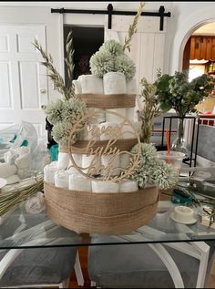 a table topped with a cake covered in white frosting and lots of succulents