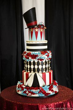 a three tiered cake is decorated with red, white and blue ribbons as well as a top hat