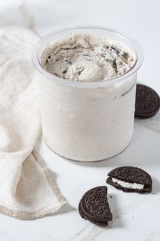 an oreo cookie ice cream in a plastic container with two cookies on the side