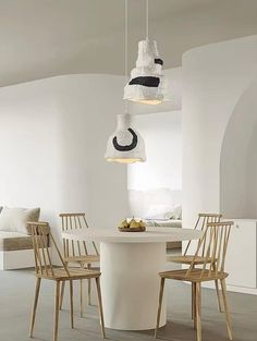 a dining room table with chairs and lights hanging from it's ceiling over it