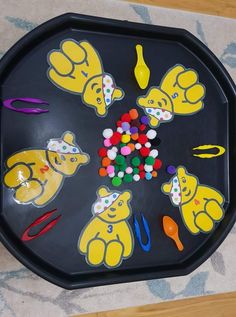 a child's play tray with various toys on the top and in the middle