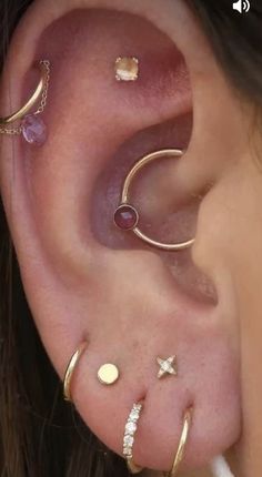 an ear with three different types of piercings on the top and bottom of it