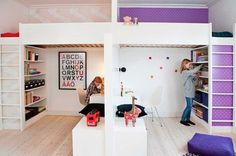 two girls are playing in the lofted room with bunk beds and bookshelves