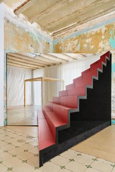 an empty room with red and black stairs