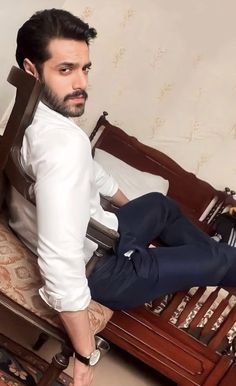 a man sitting on top of a wooden bed