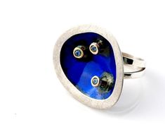 Handmade Modern Statement Ring.  Sterling silver, 18k gold,  Kiln-fired enamel contemporary design in  blue enamel with 3 matching zircons. Solid ring with unique design inspired by my vision of modern Japanese esthetics. Fun and quirky. You'll love the look and feel of this ring and it brightens up whatever you are wearing! Weighs 15g, is 3 cm wide and 3.4 cm high. Japan CollectionCustomized to your ring size.  Ready to ship. NOW ON SPECIAL OFFER. Was $195, NOW $175.Please feel free to browse i Modern White Gold Rings With Enamel, Blue Enamel Polished Round Ring, Blue Polished Enamel Ring, Blue Enamel Ring With Polished Finish, Blue Enamel Ring With Polished Finish As Gift, Blue Enamel Ring With Polished Finish For Gift, Blue Hallmarked Enamel Ring, Blue Oval Enamel Rings, Contemporary Blue Jewelry For Gifts