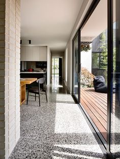 the hallway is lined with black and white tiles, along with an outdoor dining area