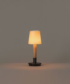 a table lamp with a white shade on it's base and a black stand