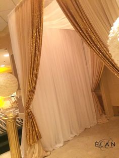 a white and gold decorated room with drapes