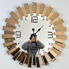 a man taking a selfie in front of a clock with multiple mirrors on it