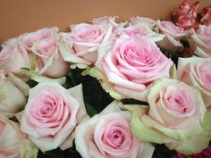 a bouquet of pink and white roses sitting on top of a table