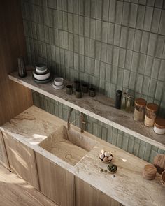 two sinks in a kitchen with green tiles on the wall