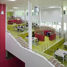 an office building with lots of desks and chairs on the second floor, along with stairs