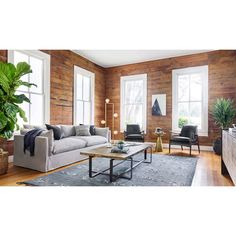 a living room filled with furniture and wooden walls