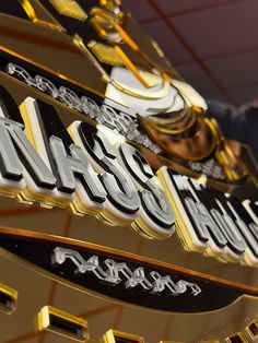 a man standing next to a golden and black sign