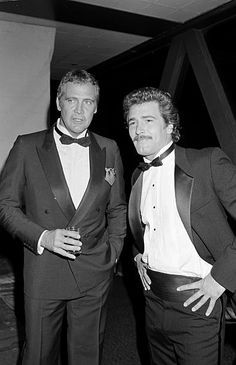 two men in tuxedos standing next to each other