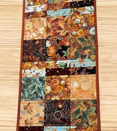 a patchwork table runner made out of many different types of autumn leaves and pumpkins