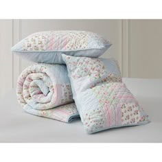 two pillows and one blanket are stacked on top of each other