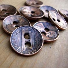 a pile of old penns sitting on top of a wooden table next to each other