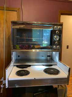 an oven with two burners on the front and one door open, in a kitchen