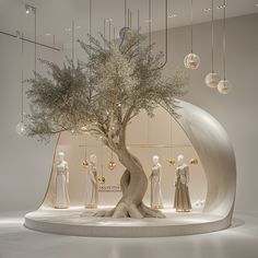 a tree in the middle of a room filled with mannequins