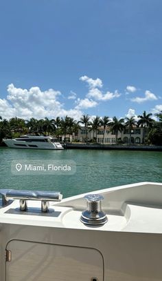 the back end of a boat traveling down a river with palm trees in the background